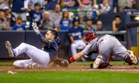 MILWAUKEE, WI - AUGUST 20: Milwaukee Brewers left fielder Ryan Braun (8) slides past Cincinnati Reds Catcher Tucker Barnhart (16) in the 8th inning of a regular season game between the Cincinnati Reds and the Milwaukee Brewers on August 20, 2018, at Miller Park in Milwaukee, WI. The Brewers won 5-2. (Photo by Jay Anderson/Icon Sportswire)
